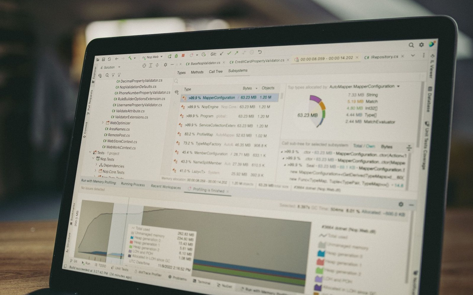 Laptop screen showing a code profiler with memory allocation charts and file trees