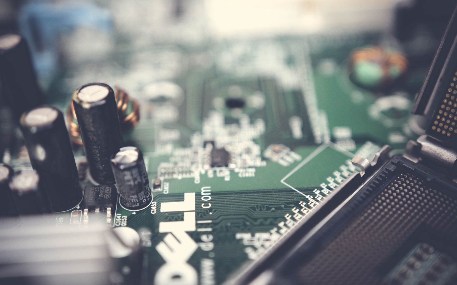 Close-up of a Dell motherboard showing capacitors, chips and an open CPU socket